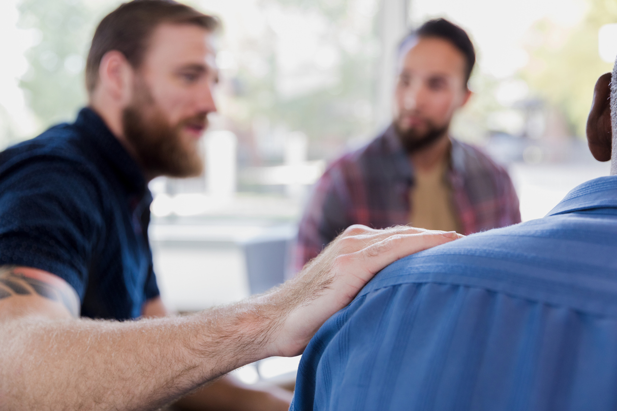 A substance abuse and recovery mental health provider serving as a therapist and leading a group therapy activity. 